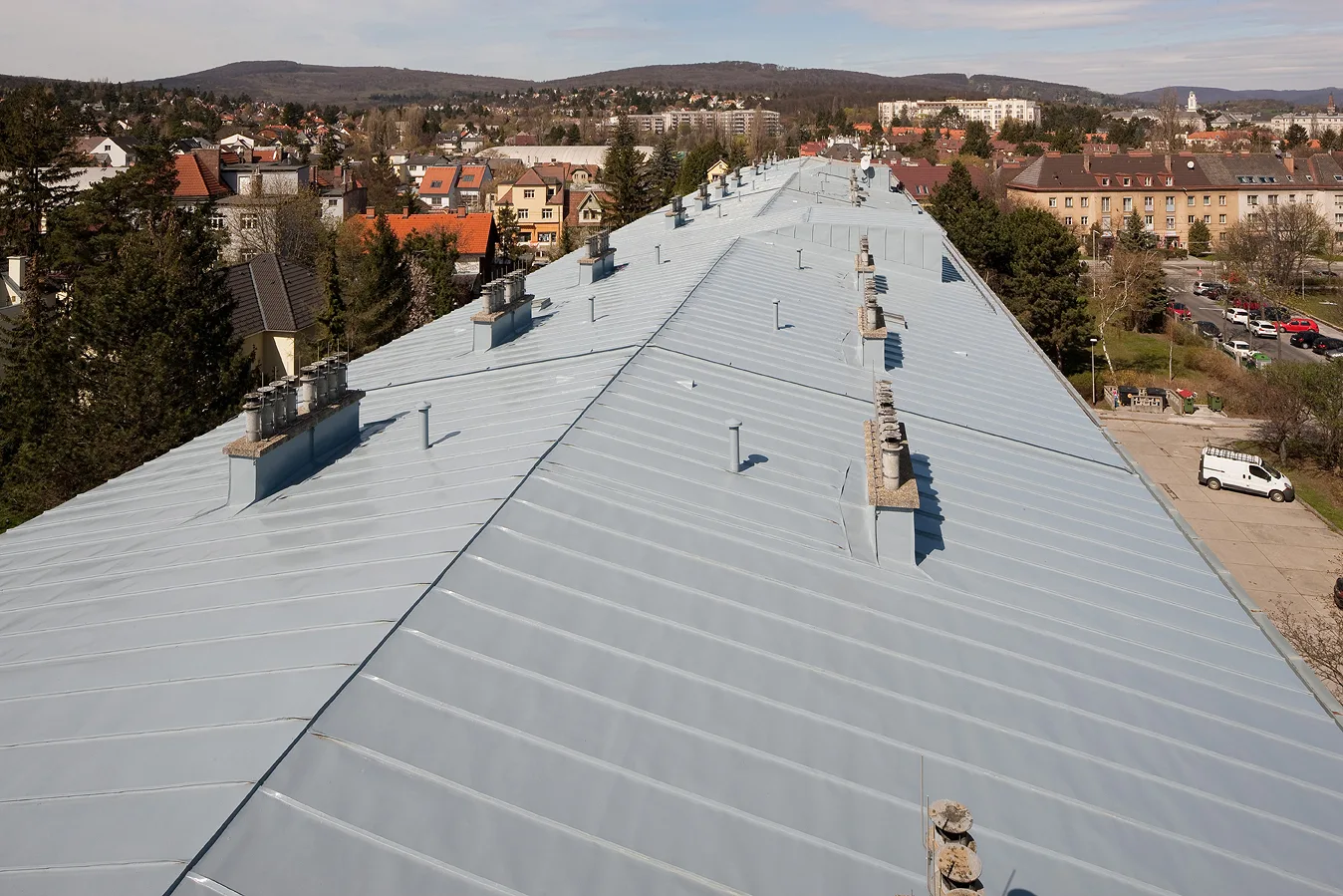 Firstansicht eines langen Stehfalz-Blechdaches mit Lüftern