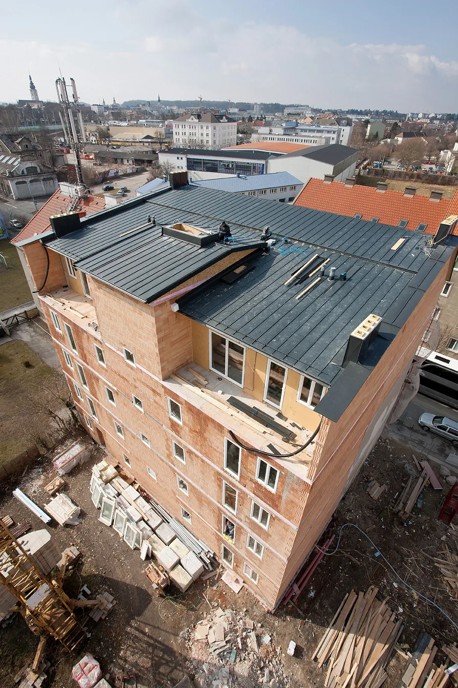 Stehfalz-Blechdach auf einem mehrgeschossigen Wohnhaus im Rohbau