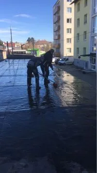 Zwei Arbeiter beim Aufbringen einer EPDM-Flachdachabdichtung