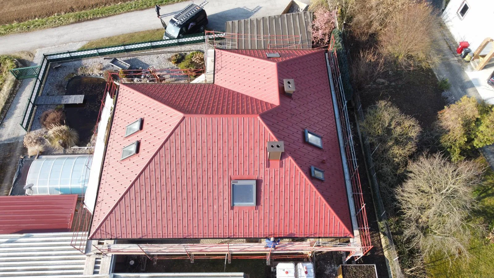 Drohnenaufnahme eines Walmdaches mit roter Ziegeleindeckung