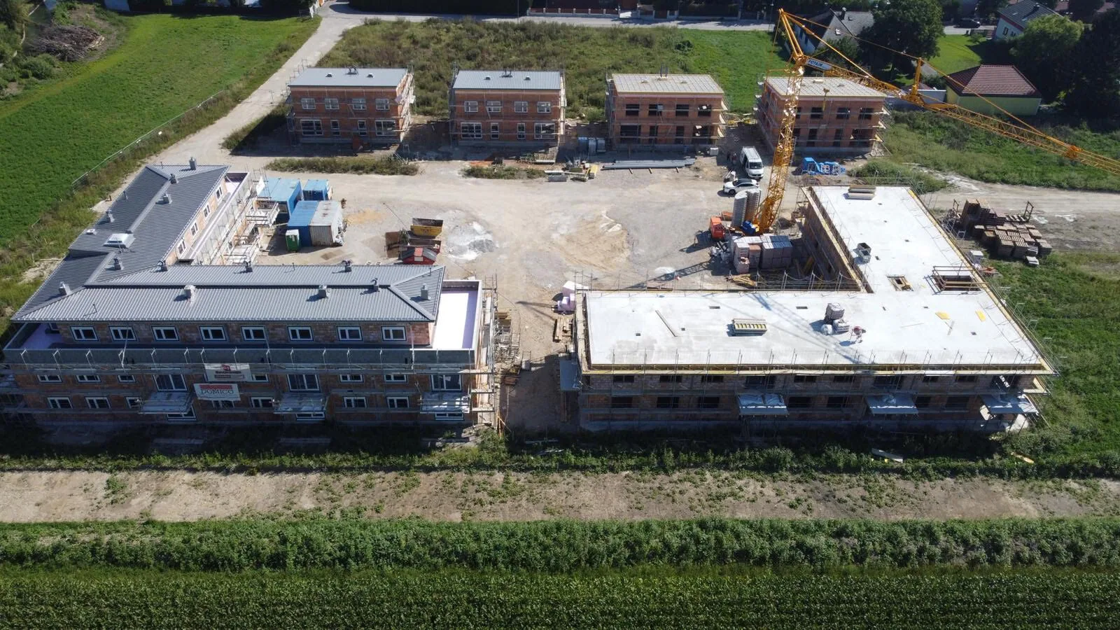 Drohnenaufnahme einer Wohnhausanlage mit neuen Flachdächern im Bau