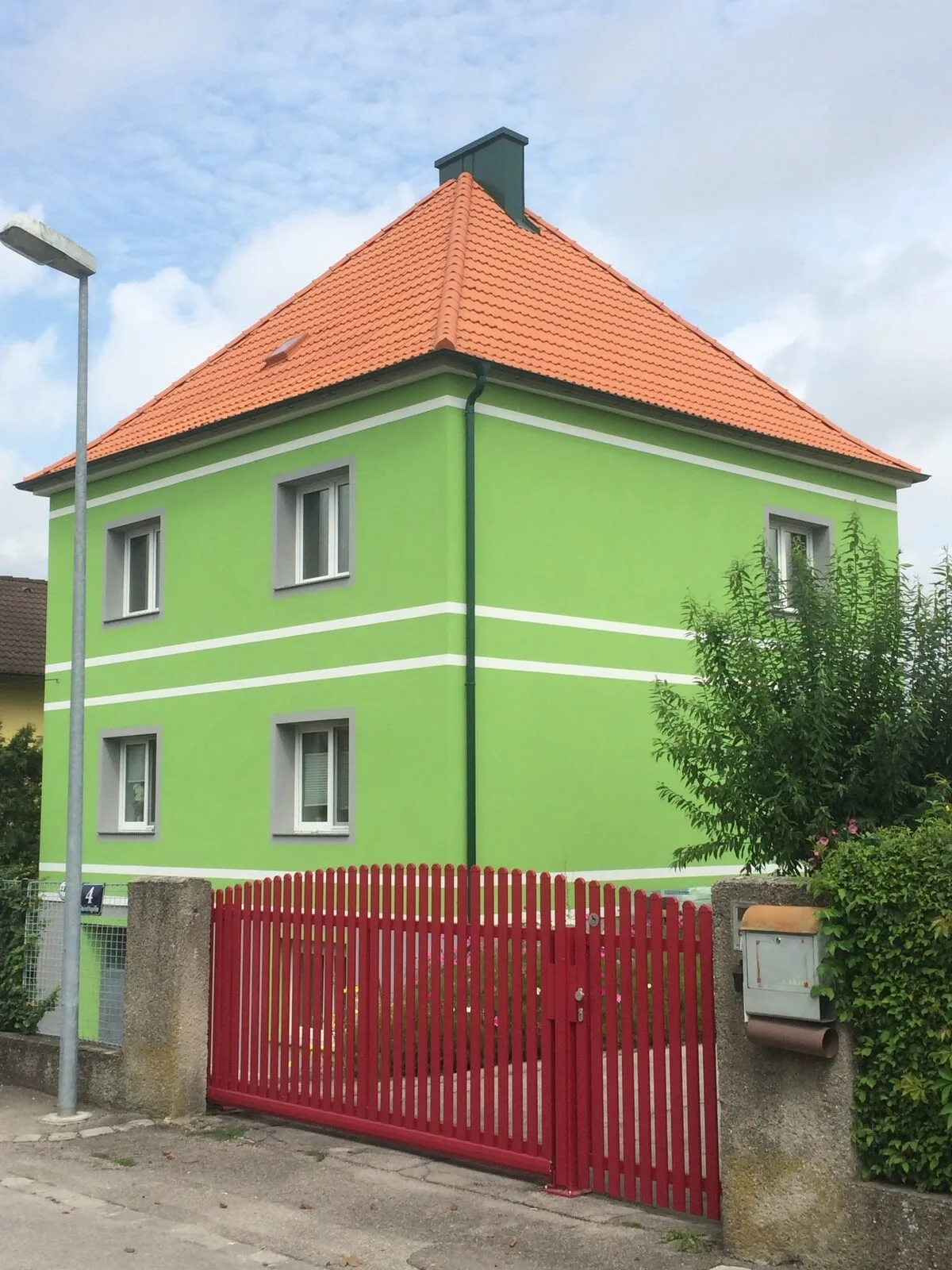 Grün verputztes Wohnhaus mit neuem Ziegeldach in Rot
