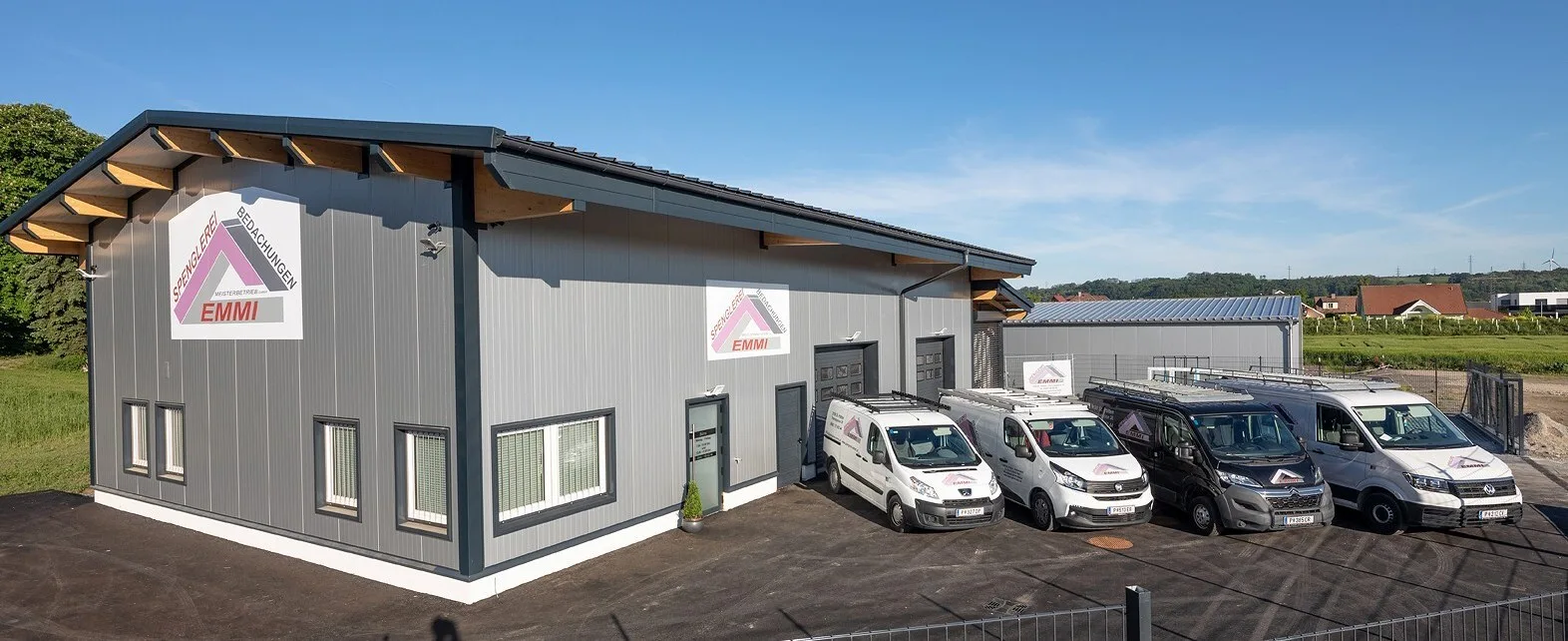 Firmensitz der Spenglerei & Bedachungen EMMI in Ratzersdorf mit vier Firmenfahrzeugen davor